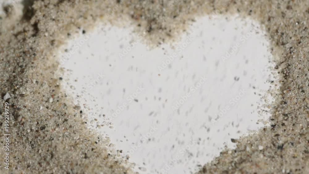 Super tight macro shot of a heart in sand. Footage of objects made out of sand blown away Super tight macro shot of a heart in sand. Footage of objects made out of sand blown away