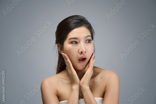 Happy beautiful asian girl with the fresh skin in white background. Expressive facial expressions. Cosmetology and Spa concept.