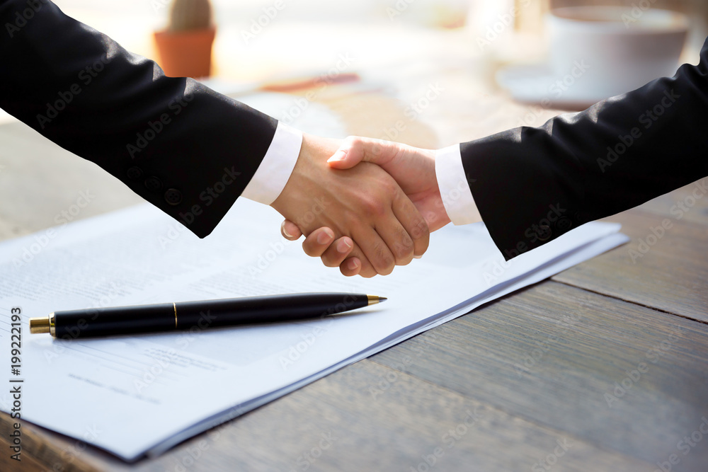 Business successful hand shaking hands over agreement form