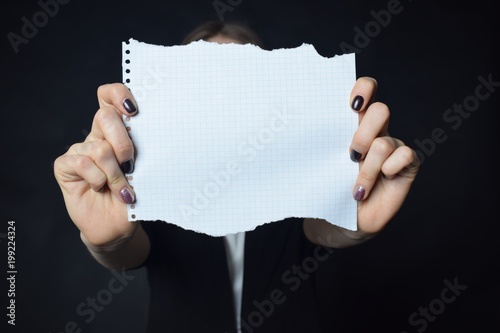 In the hands of a businessman a scrap of paper with the inscription: