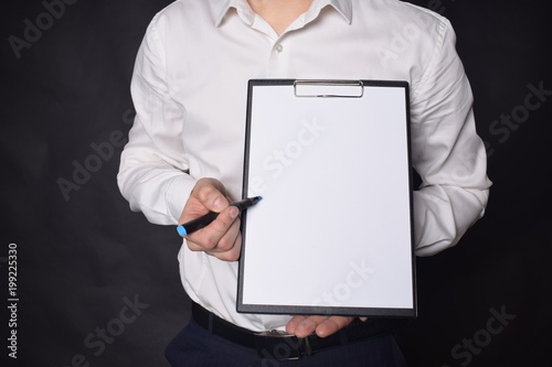 In the hands of a businessman a notebook with the inscription: