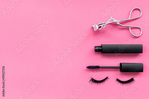 Fototapeta Naklejka Na Ścianę i Meble -  Makeup set for expressive eyelashes. Mascara, false eyelashes, eyelash curler on pink background top view space for text