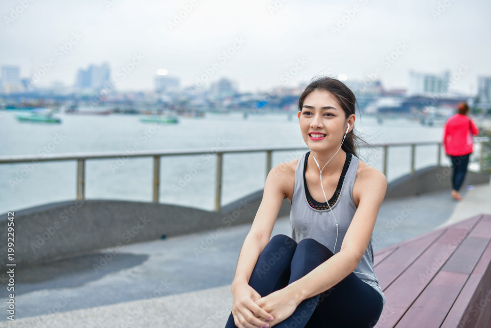 Sports concept. Beautiful girl is exercising on the beach with warm up. Beautiful girl is happy to exercise.