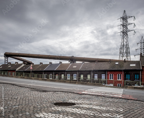 Street houses dominated by industrial gas supply pipes in the Rue du Châtelet in Charleroi, Belgium photo