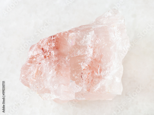 rough crystal of rose quartz gemstone on white