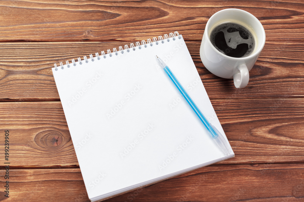 Office desk table top view. Notepad with blank pages on wooden table Office desk table top view. Notepad with blank pages on wooden table