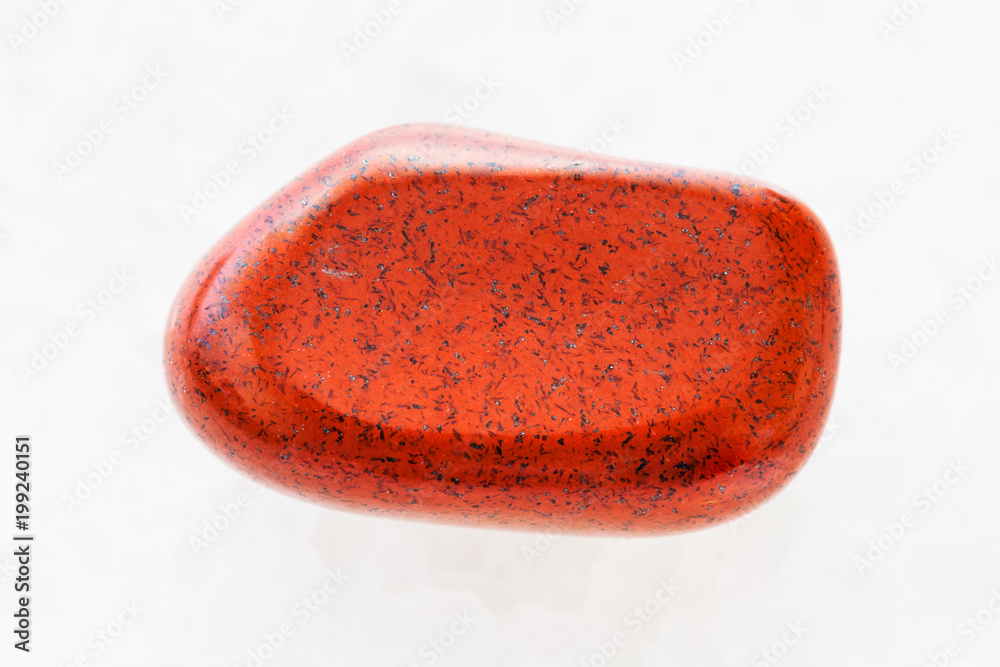 tumbled red jasper gemstone on white marble