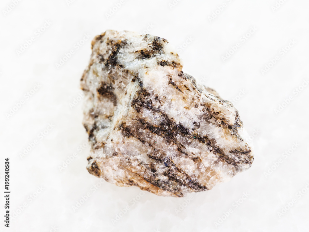 raw Gneiss stone on white marble raw Gneiss stone on white marble