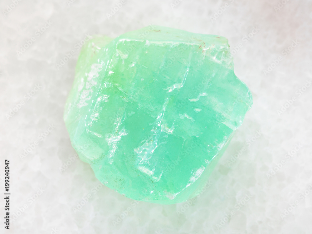 rough green Calcite stone on white marble rough green Calcite stone on white marble