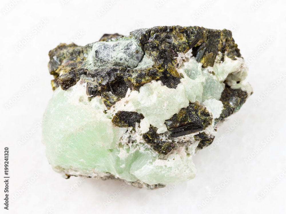 Epidote crystals on prehnite gemstone on white