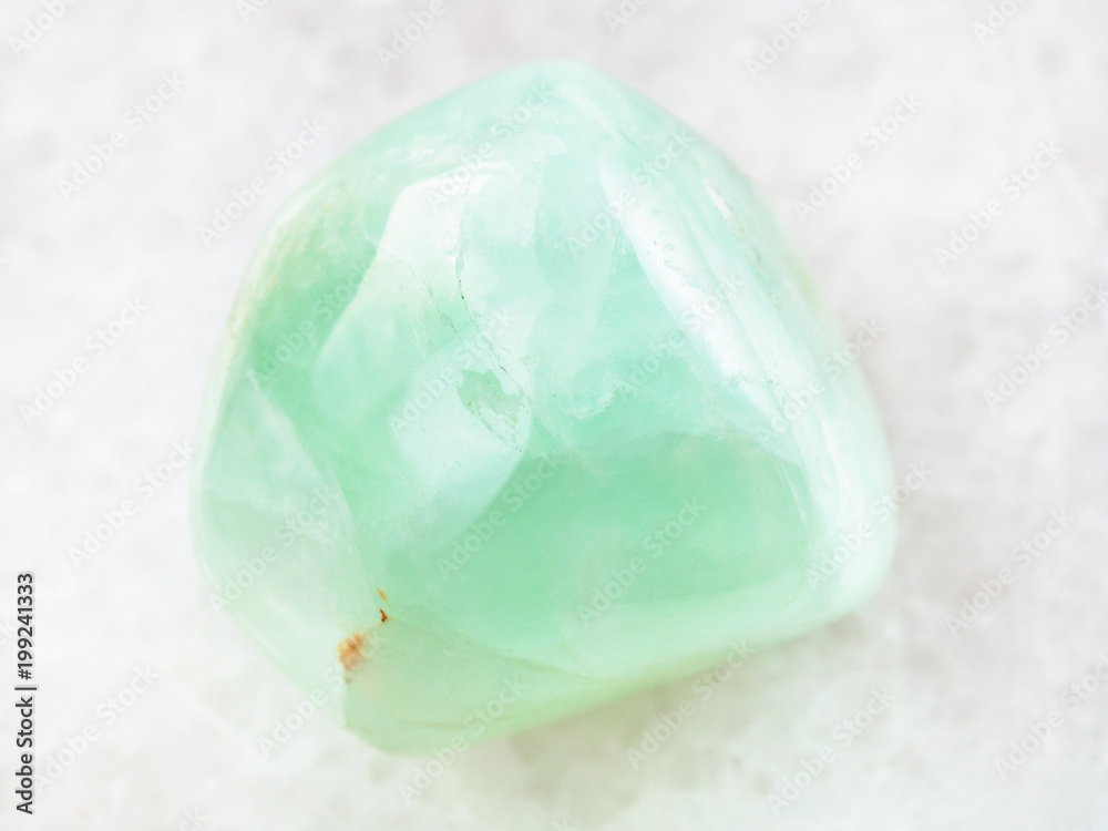 Prehnite gemstone on white marble Prehnite gemstone on white marble
