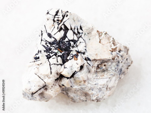 Ilmenite black crystals on stone on white photo