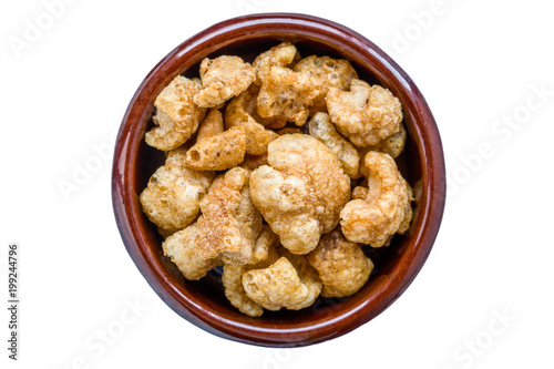 Pork rinds served in clay pot. Appetizer that consists of frying the skin and subcutaneous fat of the pig. White isolated.