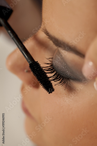 Closeup of makeup artist applying mascara