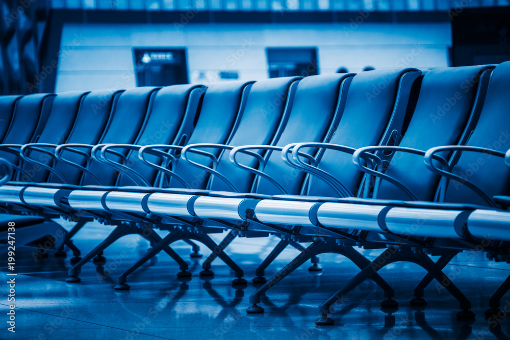 Fototapeta premium row of empty blue seats in airport lobby,blue toned,china.