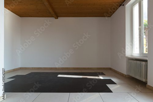 Empty room with wooden ceiling and grey tiles