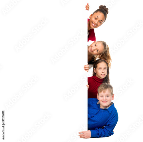 smiling teenagers peeking out from behind an empty blank