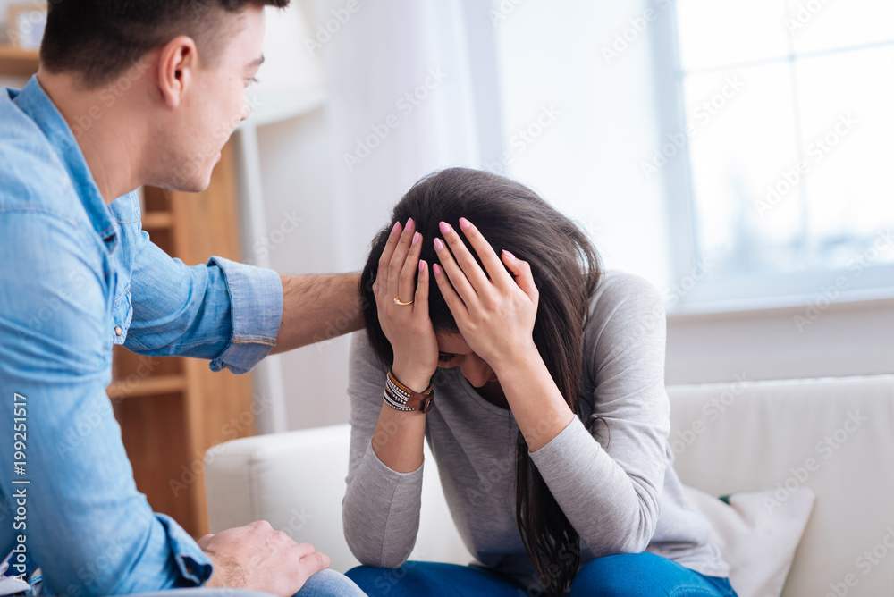 No tears. Sad desperate woman touching her had while man pacifying her No tears. Sad desperate woman touching her had while man pacifying her