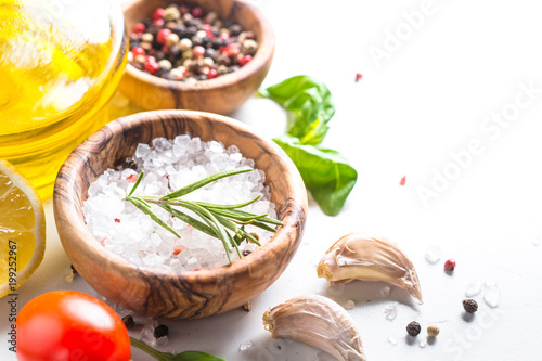 Spices, herbs and olive oil over white stone table.
