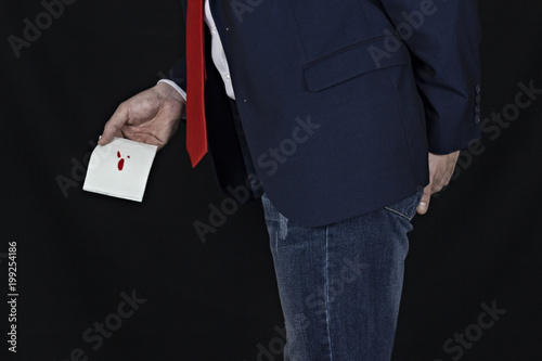 .Man in suit holds toilet paper with blood, hemorrhoids, black background