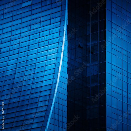 full frame of modern glass building blue toned.