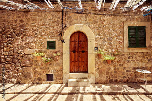 Detail of old door gateway and a window in Mallorca with flower decoration on sides