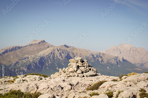 Touristic pyramid sign from rocks at top of  mountain Tomir with view of Puig Major - right - and Puig de Massanella - left photo