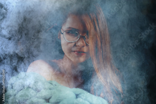 portrait of a woman in a smoke, eyes in glasses / business concept, beautiful woman, sexy business girl. Stress, smoking, relaxed.