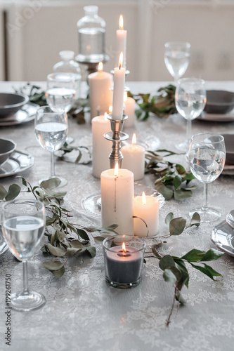 Wedding or festive table setting. Plates, wine glasses, candles and cutlery