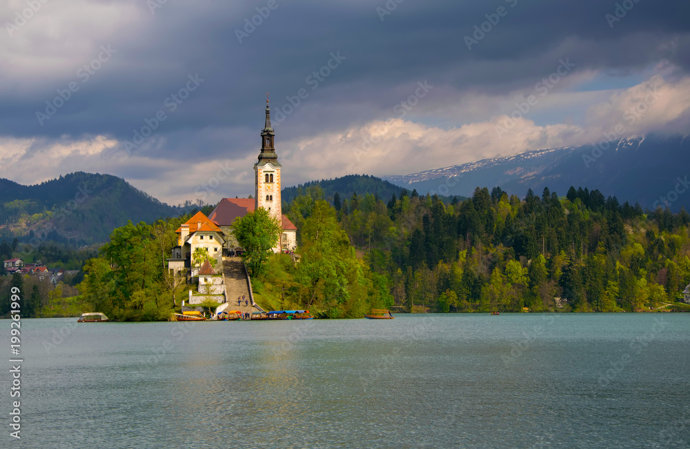 Bled lake and pilgrimage church in sunlit with dark background