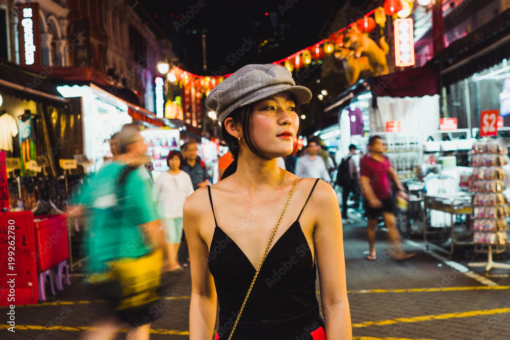 Stylish Asian woman on street at night Stylish Asian woman on street at night