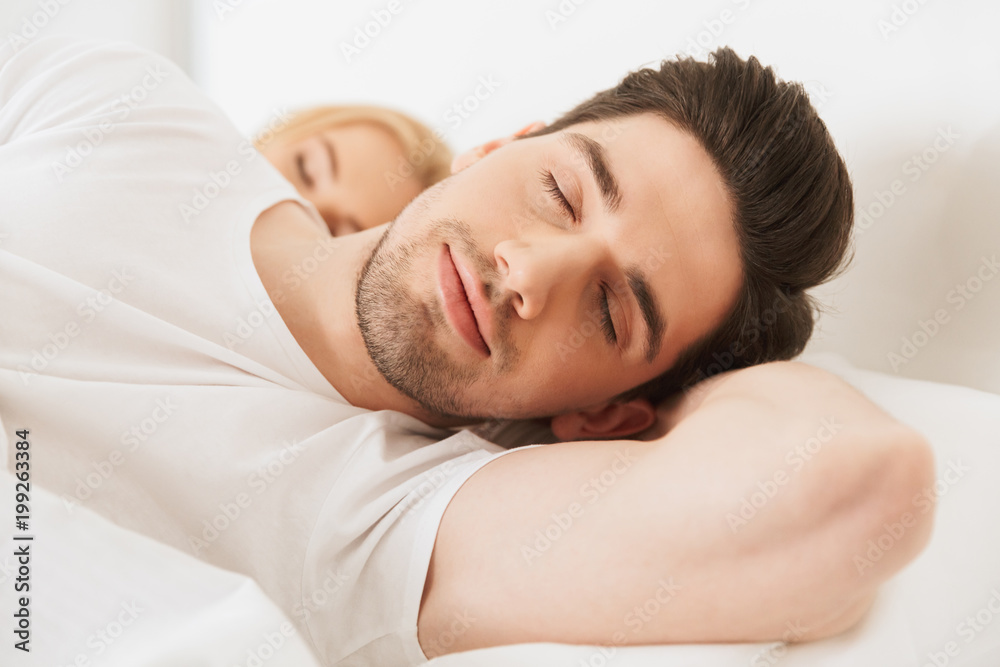 Loving couple lies in bed sleeping indoors at home. Loving couple lies in bed sleeping indoors at home.