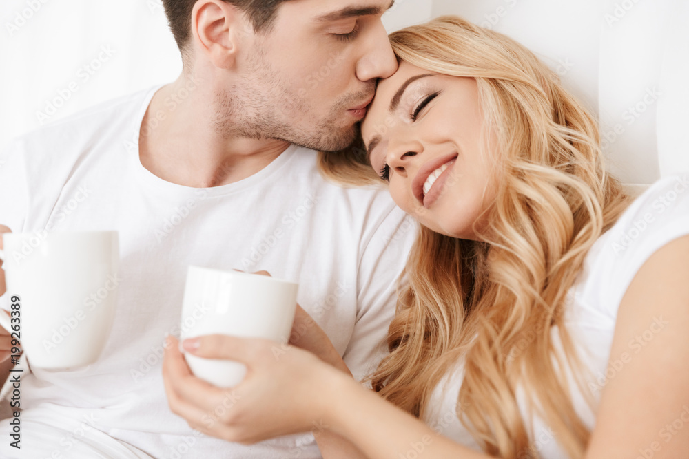 Happy loving couple in bed indoors at home Happy loving couple in bed indoors at home