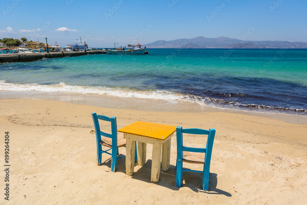Table with chairs with view on sea bay on Agia Anna beach, Naxos Island. Greece. Table with chairs with view on sea bay on Agia Anna beach, Naxos Island. Greece.