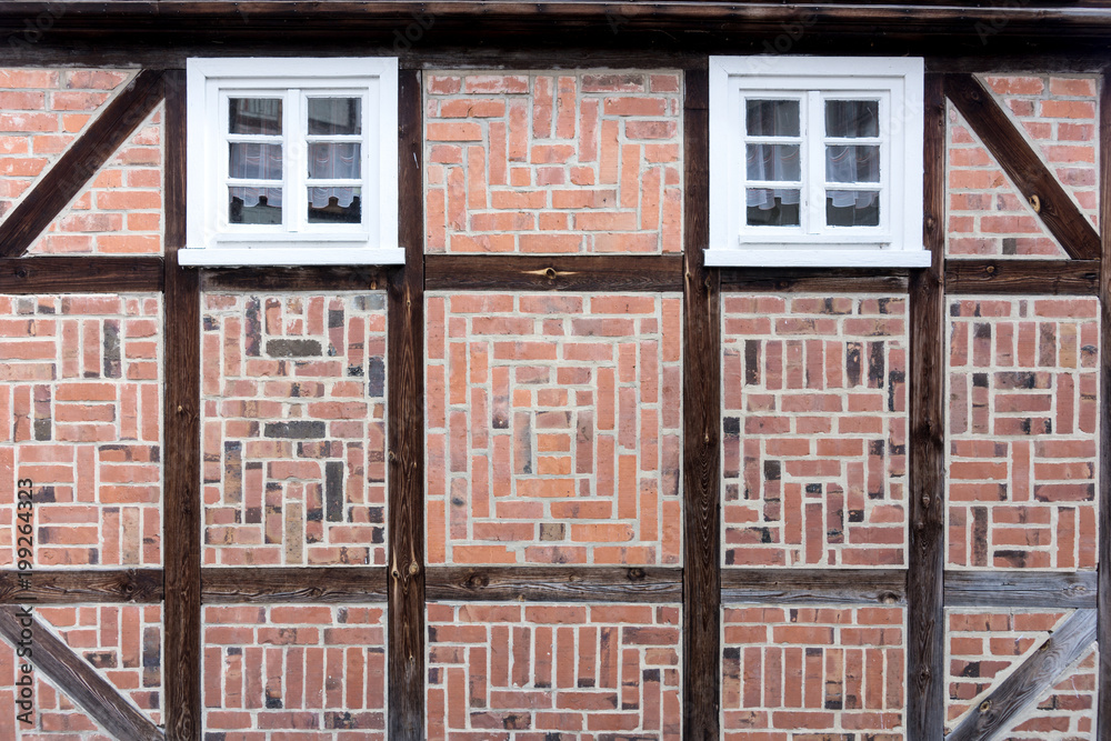 Old half-timbered facade with windows. Detail of half-timbered facade