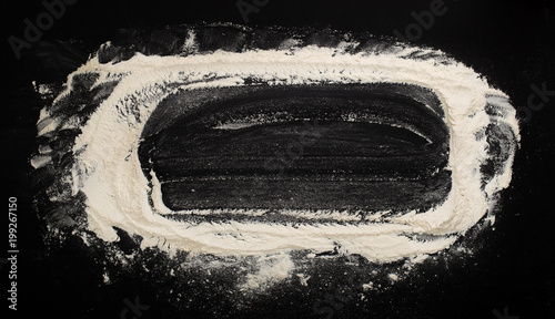 Obraz na płótnie background with flour sprinkled on a black table with a rolling pin on the side w salonie