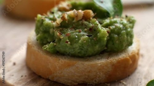 Slow motion food: large grains of pepper fall on toast with avocado spead photo