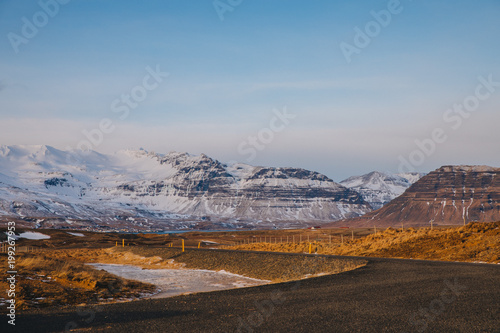 beautiful icelandic landscape with empty road and snow-covered mountains