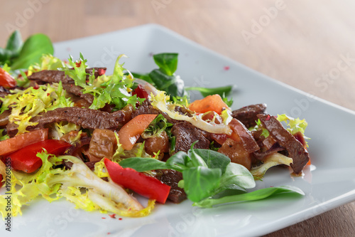beef slices in spicy sauce with vegetables, Peking cabbage and corn salad