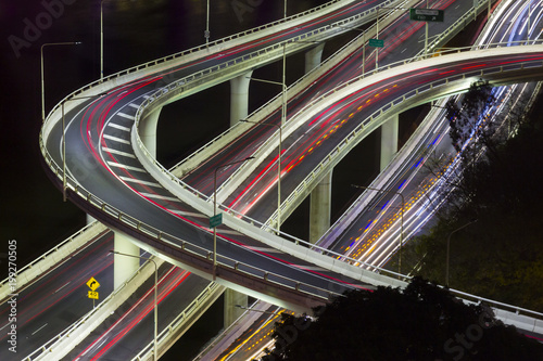 Aerial view of modern urban traffic road at night. Cityscape overpass with light trails. Brisbane Riverside Expressway, Australia.