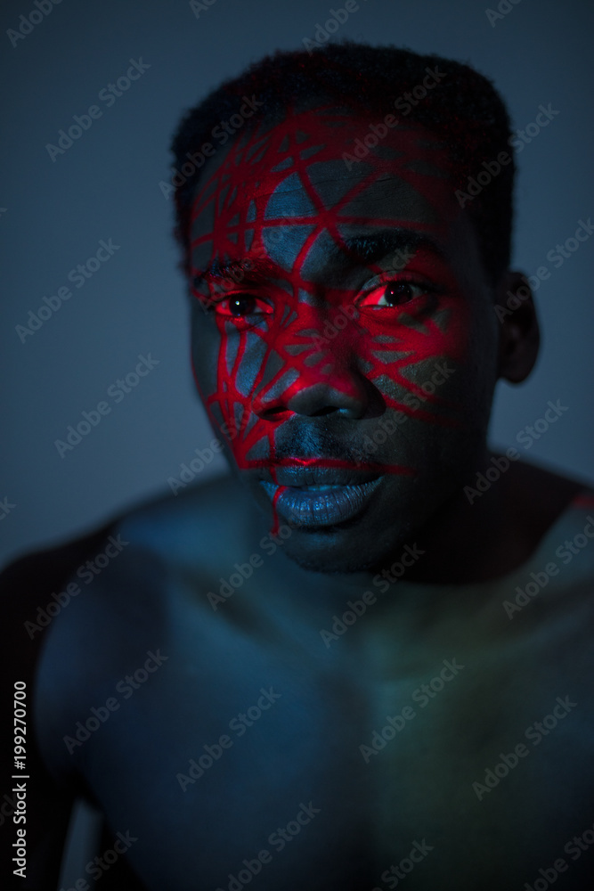 Black man with red paint on face Black man with red paint on face