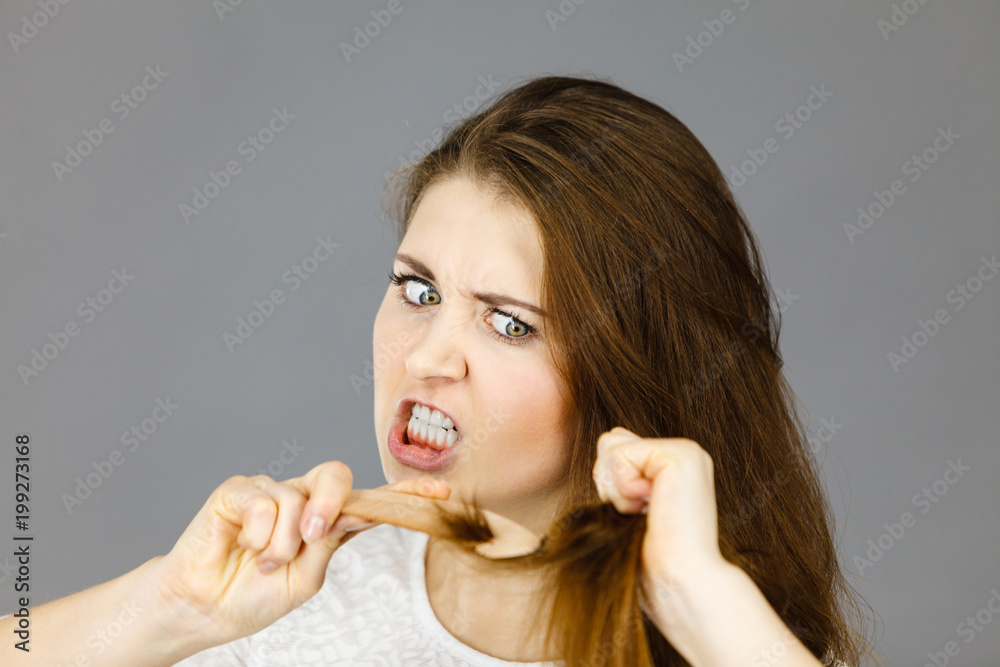 Angry woman trying to brush her hair Angry woman trying to brush her hair