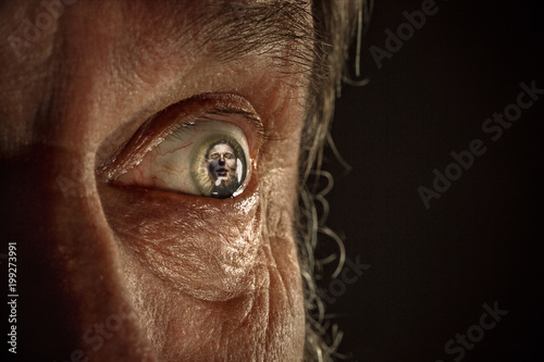 Half face of aggressive man looking with hatred into camera, domestic tyrant