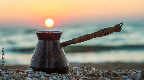 coffee cezve on the coast at sunrise photo