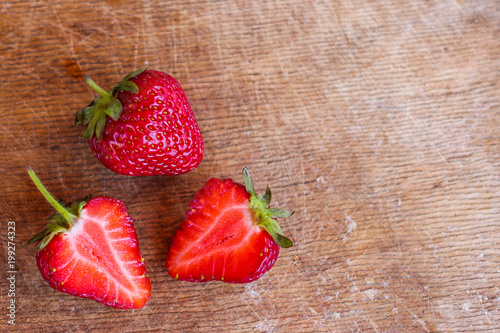three strawberries on a wooden table