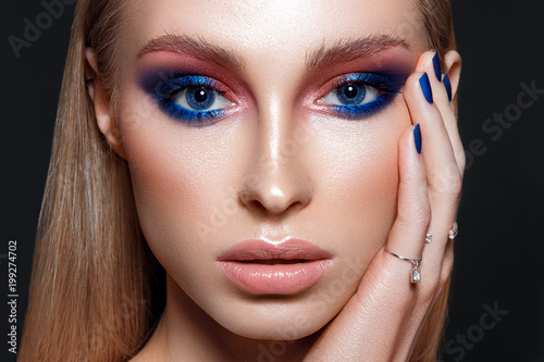 Beautiful woman portrait with blue glamour make up and blue nails.