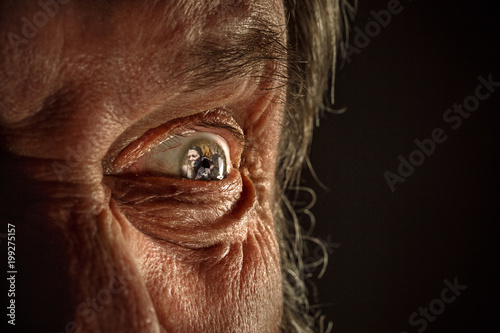 Φωτογραφία Half face of aggressive man looking with hatred into camera, domestic tyrant