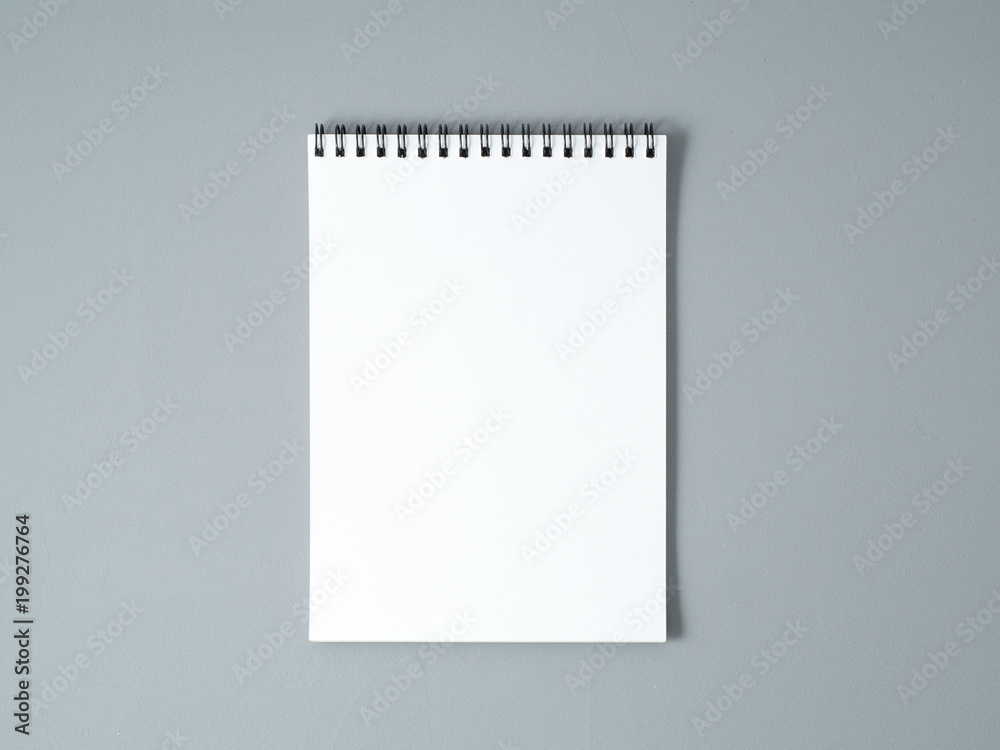 blank sheet of notebook with a spiral on a neutral gray textured background blank sheet of notebook with a spiral on a neutral gray textured background