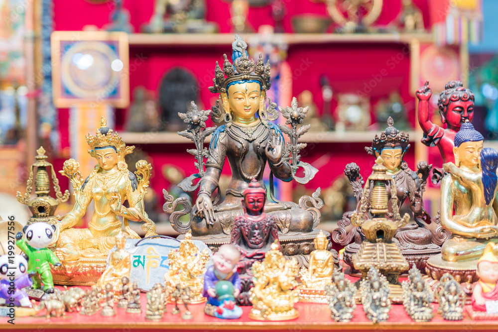 Ethnic objects on a stand. Ornamental gold statuettes representing ethnic, Indian, Hindu and Buddhist deities