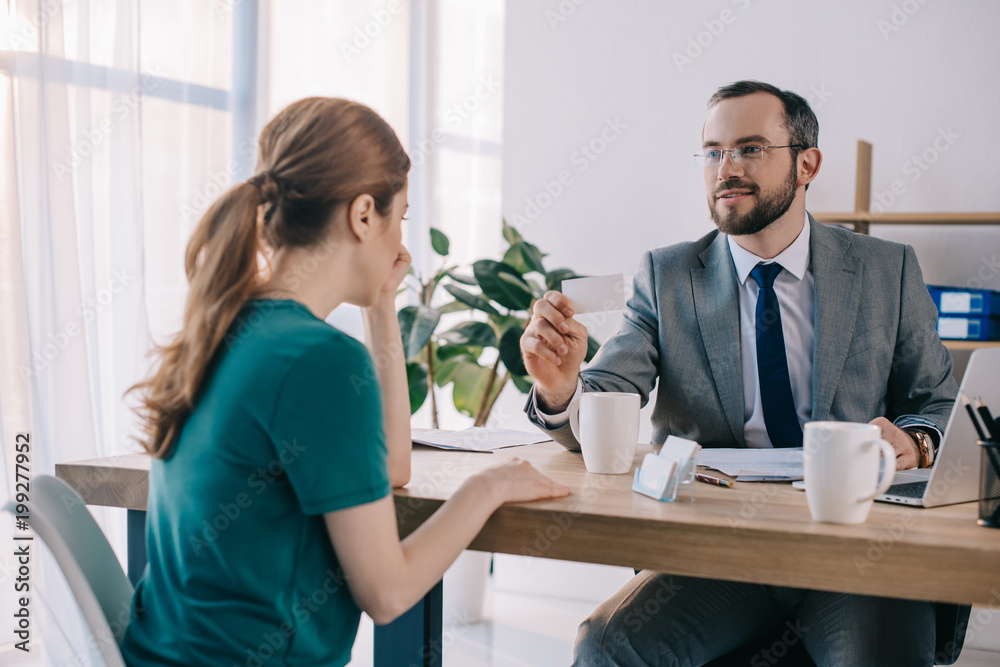 businessman showing blank card to client during meeting in office businessman showing blank card to client during meeting in office